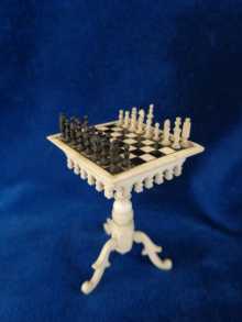 Antique miniature chess table with tiny chess figures, made of ox bone, dated about 1890.