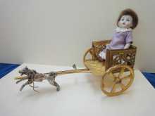 Antike Kutsche aus Goldblech mit Hund und mit antiker Puppe aus Bisquitporzellan, um 1900.
